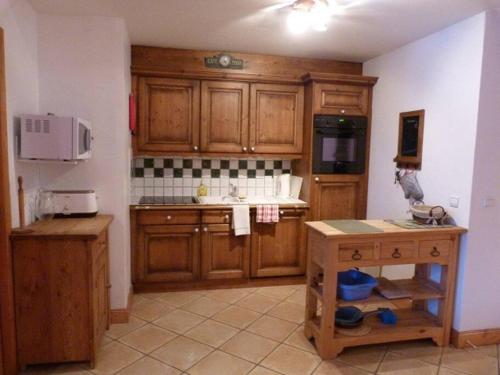 une cuisine avec des armoires en bois et un comptoir dans l'établissement Georgette - 3 bedroom apartment in the centre of Sainte Foy, great views, à Sainte-Foy-Tarentaise