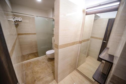 a bathroom with a toilet and a shower stall at Avenue 11 Premium Stays Madurai in Madurai