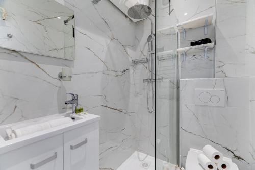 une salle de bain blanche avec une douche et un lavabo dans l'établissement Hérold - Wifi, AC, Balcony, 2 pers, à Nice