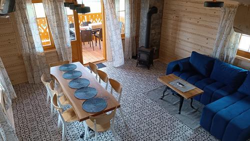 a living room with a table and a blue couch at Beskidzka Ostoja - Miejsce z duszą in Ustroń