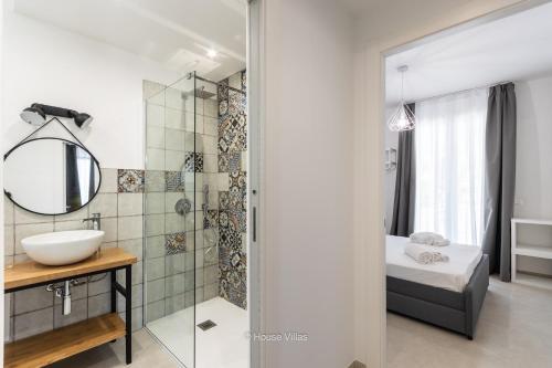 La salle de bains est pourvue d'une douche, d'un lavabo et d'un miroir. dans l'établissement House & Villas - Boutique Apartments, à Avola