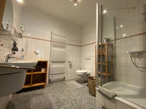 een badkamer met een wastafel, een toilet en een douche bij Ferienwohnung Heideschmetterling in Hermannsburg