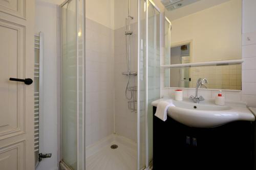 une salle de bain avec un lavabo et une douche dans l'établissement Mon toit carcassonnais •Hypercentre •Terrasse •Vue, à Carcassonne