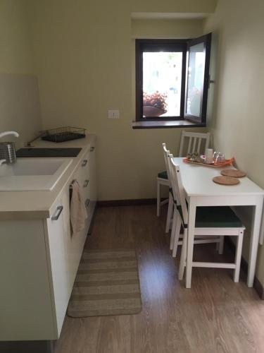 a kitchen with a table and a sink and a table and chairs at Casa Vacanze Rio Casaletto in Casaletto Spartano
