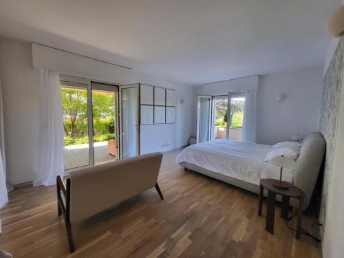 - une chambre avec un lit, un canapé et des fenêtres dans l'établissement Rez-de-Villa 