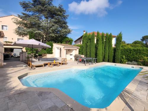 une piscine avec une table et un parasol dans l'établissement Rez-de-Villa 