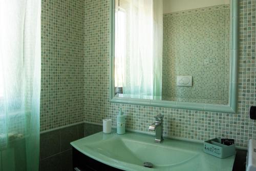 W łazience znajduje się umywalka i lustro. w obiekcie Marath houses 2 w mieście Marta