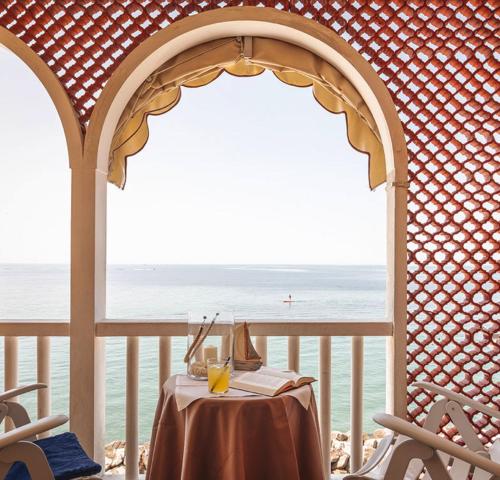 un tavolo su un balcone con vista sull'oceano di Villa Marin a Grado