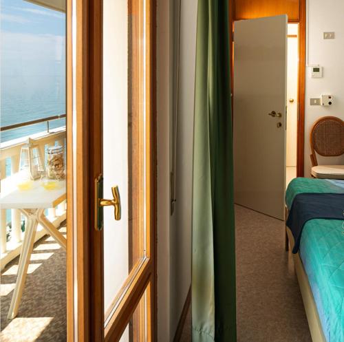 una porta che conduce a una camera con letto e balcone di Villa Marin a Grado