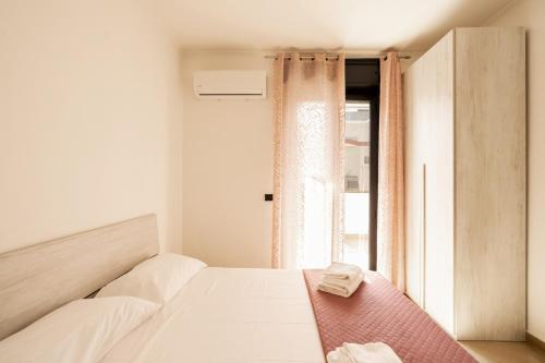 Casa Lungomare IX Maggio by Wonderful Italy في باري: غرفة نوم بيضاء بها سرير ونافذة