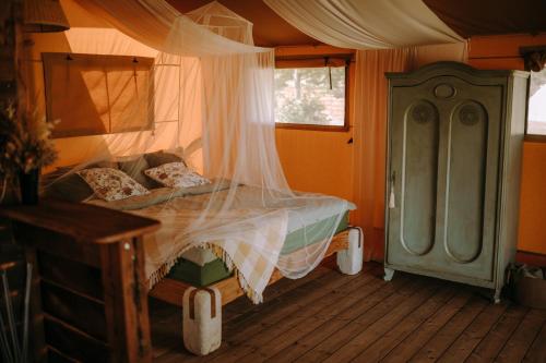 ŁowyńにあるFreedolina Glampingの窓付きの部屋にベッド付きのベッドルーム1室があります。