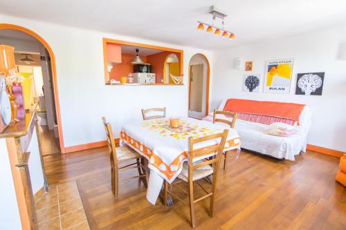 une salle à manger avec une table et un canapé dans l'établissement Volets Bleus et Briques Rouges, à Albi