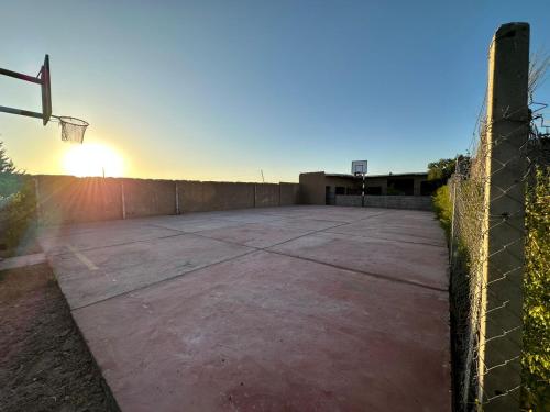 Paradise : ملعب كرة سلة فارغ مع غروب الشمس في الخلفية