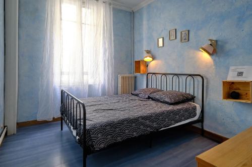 une chambre avec un lit dans une pièce avec une fenêtre dans l'établissement Mon toit carcassonnais •Hypercentre •Terrasse •Vue, à Carcassonne