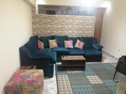 un sofá azul con almohadas en la sala de estar en Luxury studio, central location, very secure, en El Cairo