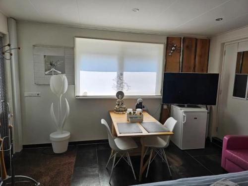a room with a table with chairs and a window at NamaStee aan Zee in Vlissingen