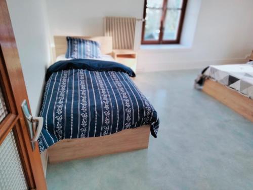 a bedroom with a bed with a blue comforter at Grand appartement de 3 chambres moderne et spacieux, entièrement meublé in Belfort