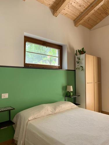 a bedroom with a bed with a green wall at La stanza in giardino in Cava deʼ Tirreni