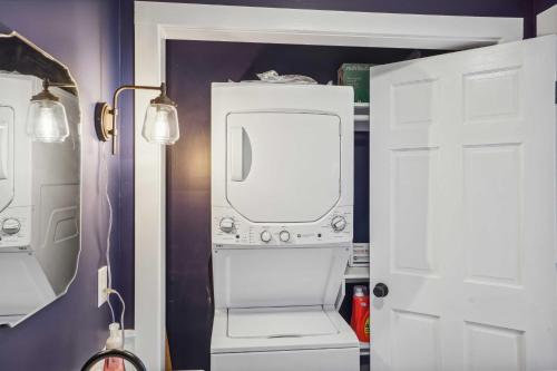 a kitchen with a white refrigerator next to a door at Kingston Crawfish Cottage Near Catskills! in Kingston