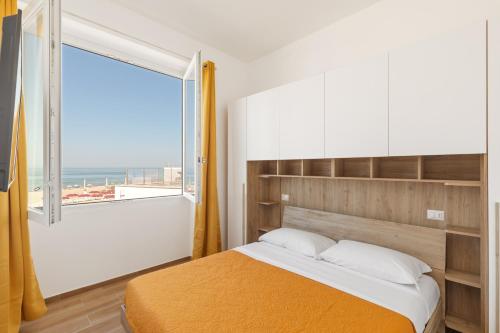 una camera da letto con un letto e una grande finestra di Residence Torvaianica a Torvaianica