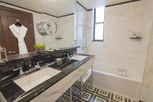 a bathroom with a sink and a tub and a mirror at Iroquois New York Times Square in New York