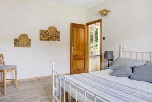 a bedroom with a bed and a wooden door at La rosa sul lago in Osiglia