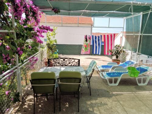 a patio with a table and chairs and flowers at Marin in Šibenik