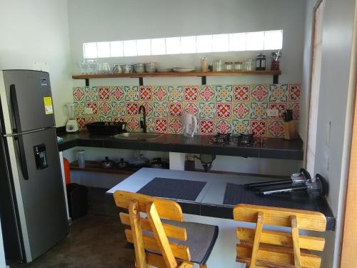 a kitchen with a refrigerator and a table and chairs at Bosque Azul Picaflor in Minca