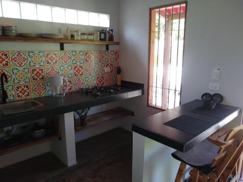 a kitchen with a counter and a table with a stove at Bosque Azul Picaflor in Minca