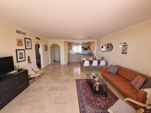 sala de estar con sofá y mesa en Elegant apartment with fantastic views At the top of Calahonda en Sitio de Calahonda