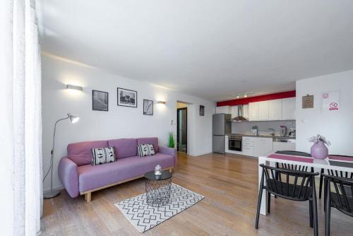 sala de estar con sofá púrpura y cocina en Sun Hill Apartments Mlini, en Mlini