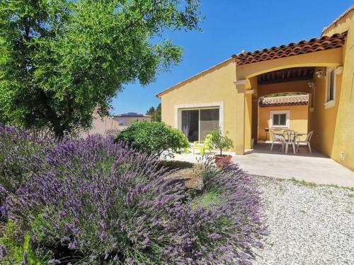 un jardín con flores púrpuras frente a una casa en Le Coteau des Cigales*Clim*Calme en Cornillon-Confoux