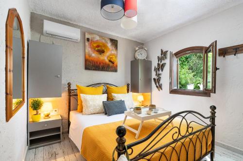 a bedroom with a bed with yellow sheets and a table at Rock and Sea View House in Sitia