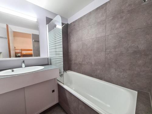 une salle de bain avec un lavabo, une baignoire et un miroir dans l'établissement Confort 2P Sud avec Balcon à 250m des Pistes, Flaine Forêt - FR-1-425-142, à Flaine