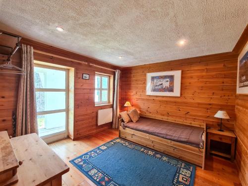 een kamer met een bed in een houten kamer met een raam bij Chalet Flaine, 5 pièces, 8 personnes - FR-1-425-123 in Flaine