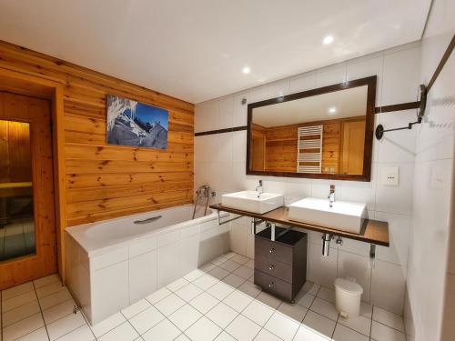 a bathroom with two sinks and a tub and a mirror at Chalet Flaine, 5 pièces, 8 personnes - FR-1-425-123 in Flaine