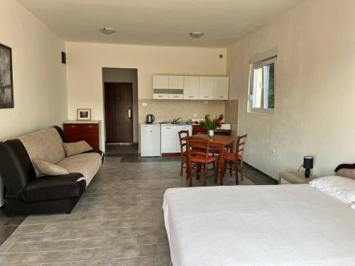 uma sala de estar e cozinha com uma cama e um sofá em Apartman DAN em Bigovo