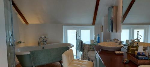 伯納姆馬基特的住宿－Beatrix Barn，浴室配有两个盥洗盆和浴缸。
