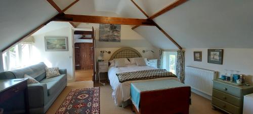 a bedroom with a bed and a couch in a room at Beatrix Barn in Burnham Market
