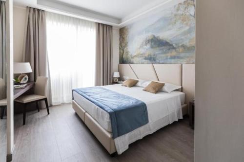 a bedroom with a bed and a painting on the wall at Villa Cavalletti in Grottaferrata