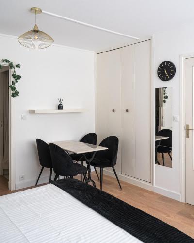 une salle à manger avec une table, des chaises et une horloge dans l'établissement Casa Lyon Cosy 1 Br Flat Part Dieu, à Lyon