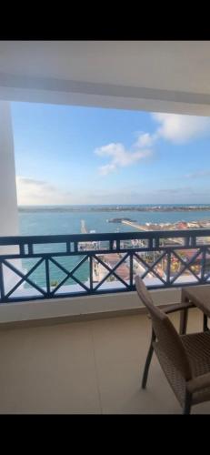 a balcony with a chair and a view of the ocean at Executive Royal Tower Apartments - Sky Lounge in El Alamein
