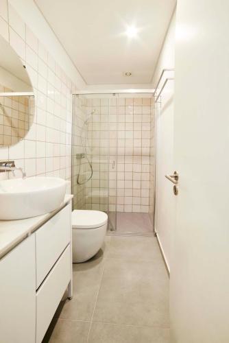 a bathroom with a sink and a toilet and a shower at Pause Apartments in Porto