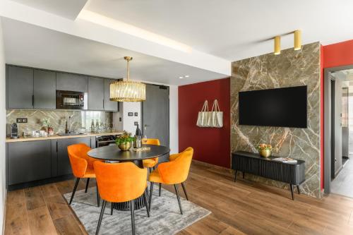 a kitchen and dining room with a black table and orange chairs at Hotel Vinifera Wine & Spa 5 Stars Superior in Balatonfüred