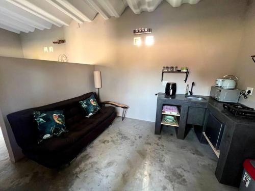 a living room with a couch and a stove at The Stables in Roodepoort