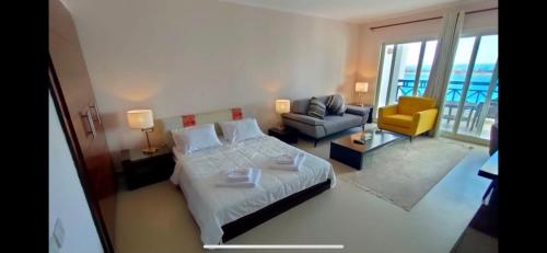 a bedroom with a bed and a couch and a chair at Executive Royal Tower Apartments - Sky Lounge in El Alamein