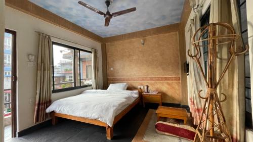 a bedroom with a bed and a window at Hotel Hakoniwa in Pokhara