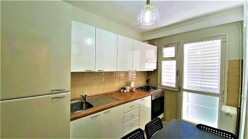a kitchen with white cabinets and a sink at Arc de Triomphe BlissBoutique in Bucharest