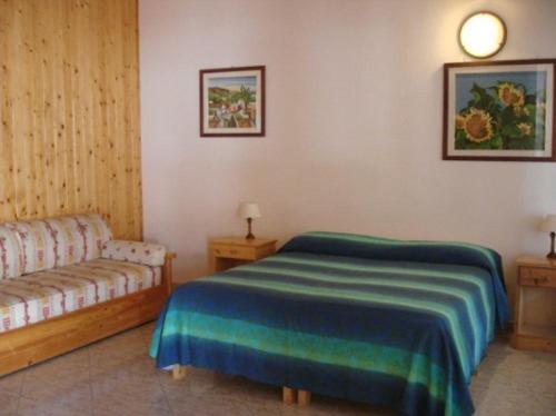 een slaapkamer met een bed en een bank bij Agriturismo Arabesque in Balestrate