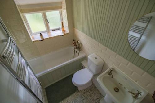 a bathroom with a toilet and a tub and a sink at Moor View in Lockton